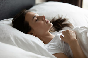 A photo of a woman sleeping to improve rest and comfort using high quality bedding and linen.