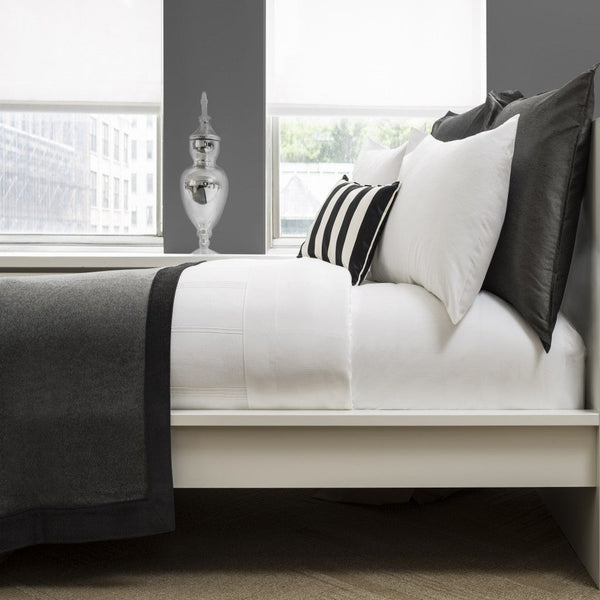 Profile of Black and white bed linens and pillows on bed.